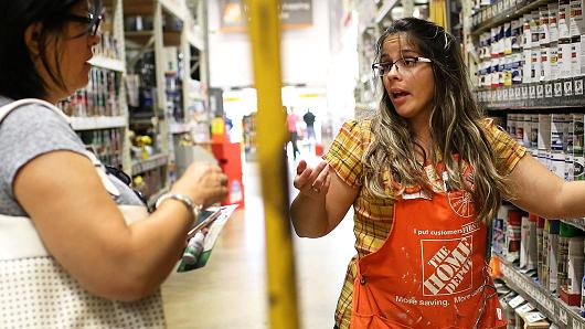 A Home Depot employee helps a shopper at the store in Miami