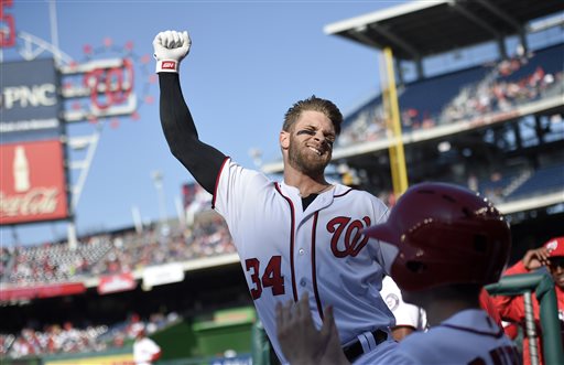 Washington Nationals Bryce Harper pumps his fist as he takes a curtain call after he hit a grand slam during the third inning of an baseball game against the Atlanta Braves Thursday