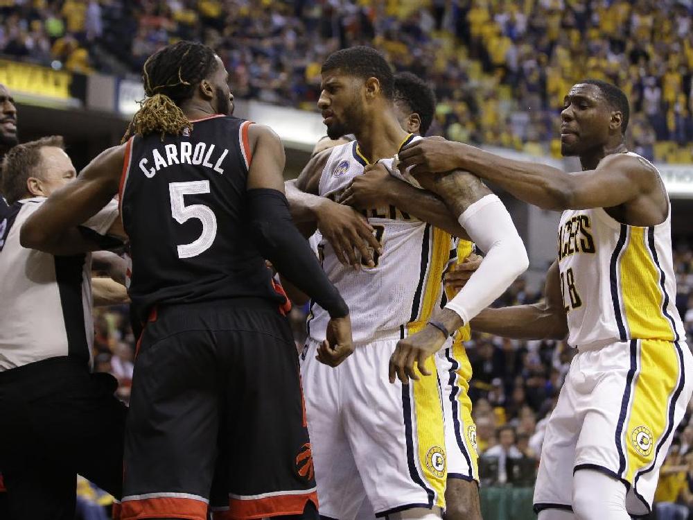 Indiana Pacers forward Paul George and Toronto Raptors&#039 De Marre Carroll are separated by teammates during the second half of Game 4 of an NBA first-round playoff basketball series Saturday