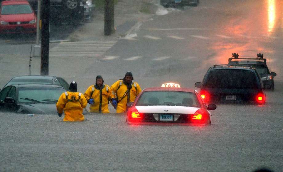 Firefighters head for higher ground after checking flooded cars for occupants on Broad Street after a line of thunderstorms dumped torrential rain across the region flooding roads in New London Conn. Thursday Sept. 10 2015