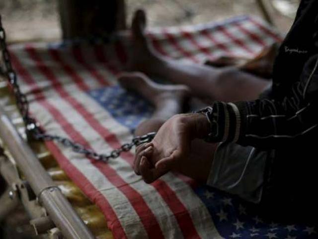 Deden a teenager whose father says suffers from mental illness lives chained to a tree under a shelter next to a rice paddy near his family home in Longkewang village in Serang Banten province Indonesia