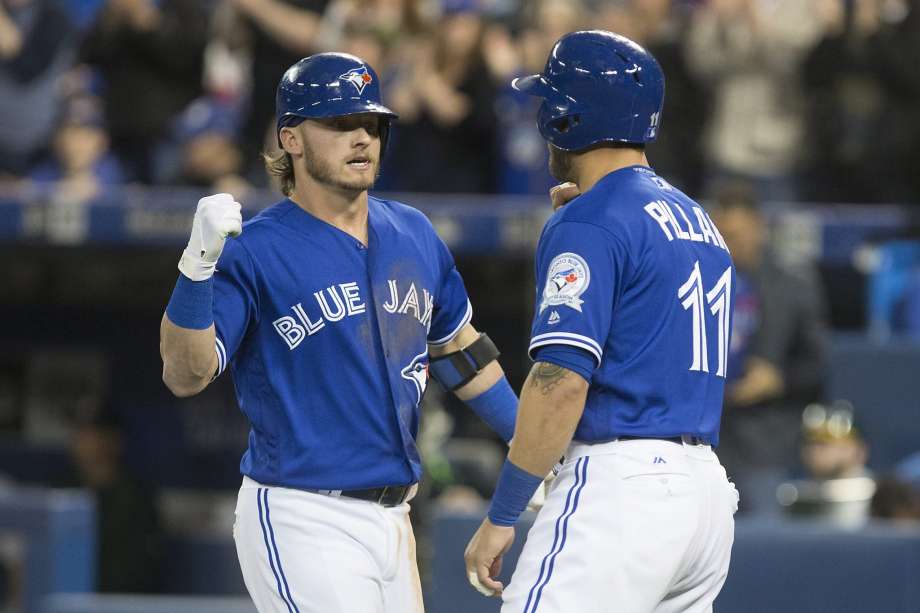 The Blue Jays’ Josh Donaldson is congratulated by teammate Kevin Pillar after hitting a three-run homer off A’s pitcher Chris Bassitt during the second inning at Rogers Centre