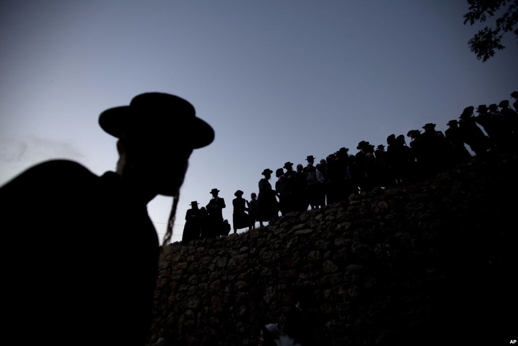 Ultra-Orthodox Jewish men gather to collect water from a spring to make matza a traditional handmade Passover unleavened bread near Jerusalem Thursday