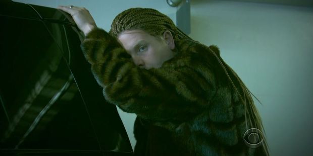 Just like Beyonce James models cornrows and a furry jacket in one parody scene