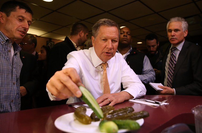 Republican presidential candidate John Kasich eats pickles while having lunch at PJ Bernstein's Deli Restaurant