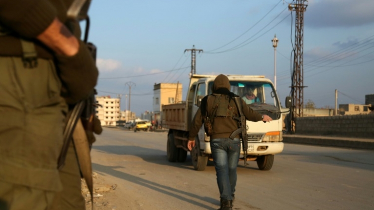 Members of the Kurdish internal security forces check vehicles in the northeastern Syrian city of Qamishli in December 2015