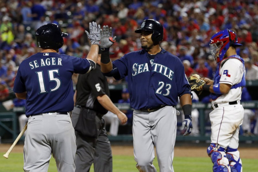 Seattle Mariners&apos Kyle Seager congratulates Nelson Cruz on his solo home run as Texas Rangers catcher Robinson Chirinos stands by the plate in the fourth inning of a baseball game Tuesday