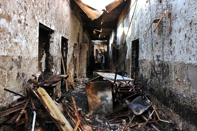 Medecins Sans Frontieres staff walk along a corridor in the damaged MSF hospital in northern Kunduz on November 10,2015