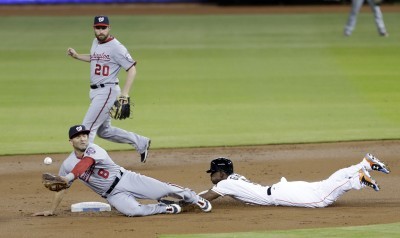 Miami’s Dee Gordon steals second base as Nationals shortstop Danny Espinosa tries to corral the throw