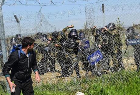 Macedonian police threw stones at migrants and refugees during clashes near their makeshift camp in the Greek border village of Idomeni on Sunday