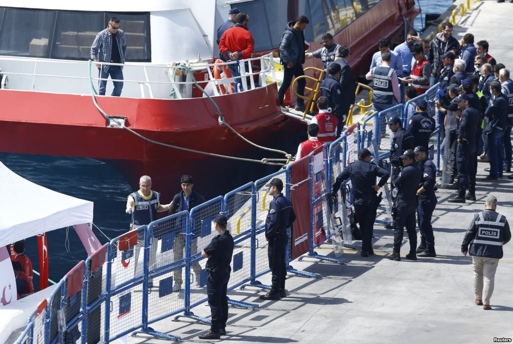 Migrants leave a ferry anchored at port in the Turkish coastal town of Dikili on April 4