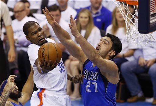 Oklahoma City Thunder forward Kevin Durant goes to the basket as Dallas Mavericks center Zaza Pachulia defends during the first half of Game 2 of a first-round NBA basketball playoff series Monday