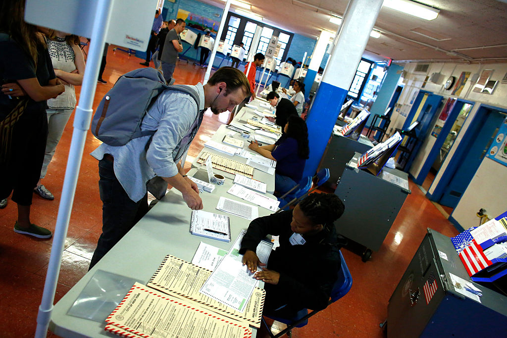 A man checks his documents before he cast his vote at a polling station in Brooklyn New York during the New York presidential primary on Tuesday