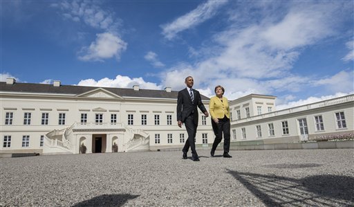 US President Barack Obama left and German Chancellor Angela Merkel arrive to inspect a military guard of honur upon arrival at the Herrenhausen Palace in Hannover northern Germany Sunday