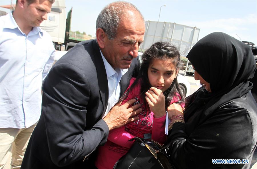 The parents of Palestinian girl Dima al-Wawi 12 who is believed to be the youngest female detained by Israel hug her upon her release from Israeli prison at Israeli military checkpoint near the West Bank city of Tu