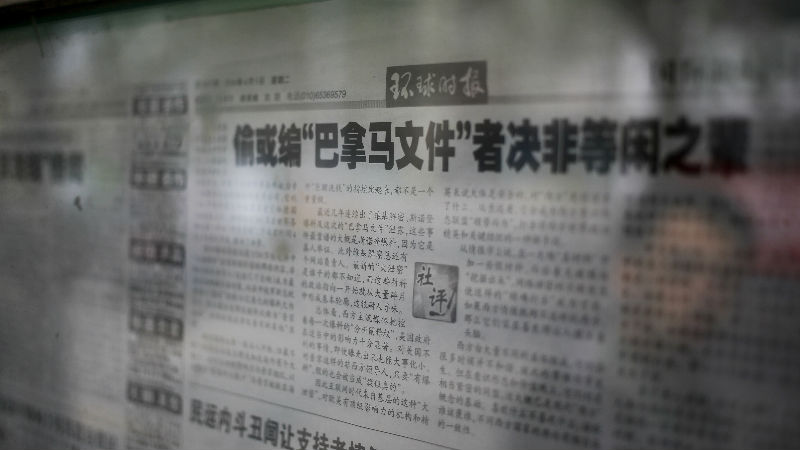 A man walks past the nationalistic tabloid Global Times editorial on'Panama reports displayed on a newspaper board in Beijing Tuesday