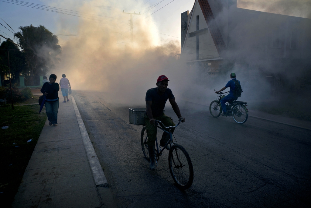 People in Pinar del Rio Cuba make their way through a fumigation fog that's meant to kill the mosquito that transmits the Zika virus