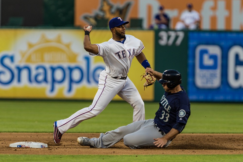 05 APR 2016 Texas Rangers shortstop Elvis Andrus throws the ball to first base as Seattle Mariners catcher Chris Iannetta slides into second base on a double play during the game between the Texas Rangers and the Seattle Mariners at Globe Life P