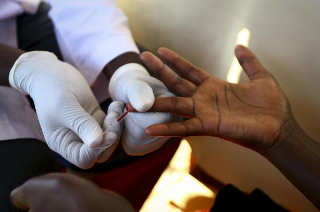 REUTERS  EDWARD ECHWALUA doctor is seen here obtaining blood from a patient to test for HIV in a mobile testing unit in Uganda