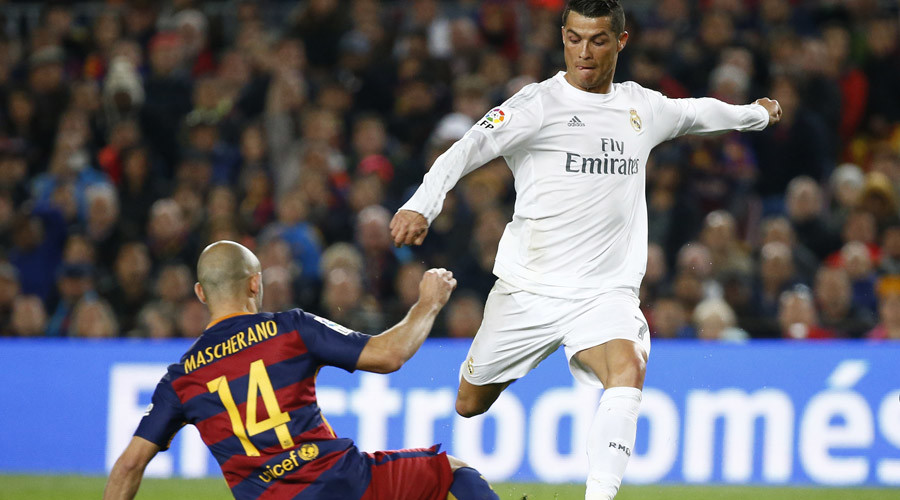 Real Madrid's Cristiano Ronaldo has a shot at goal under pressure from Barcelona's Javier Mascherano