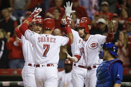 Cincinnati Reds Eugenio Suarez celebrates with his teammates after hitting a go-ahead three-run home run off Chicago Cubs starting pitcher John Lackey in the sixth inning of a baseball game Saturday