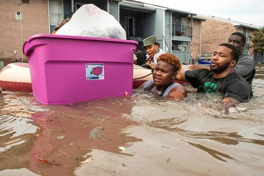 Residents evacuate their flooded apartment complex in the Greenspoint area of Houston