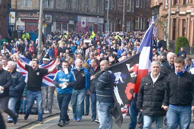 Rangers fans march towards the match