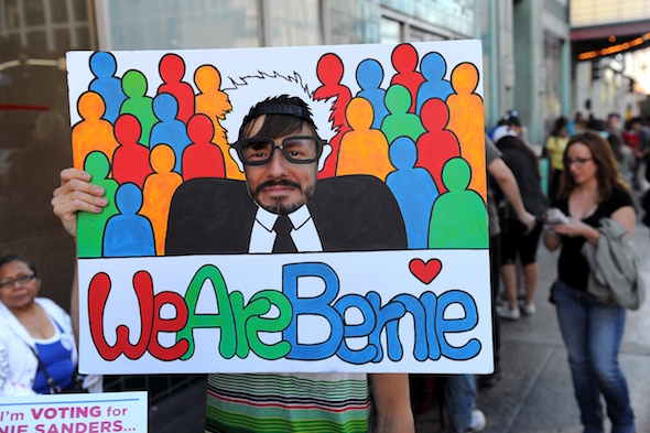 Scott Sorensen of Echo Park sticks his face in a Bernie Sanders sign at rally for the candidate