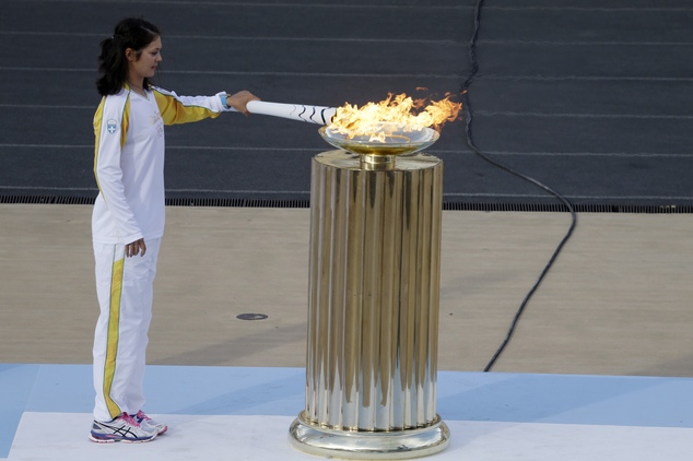 Rowing World Champion Katerina Nikolaidou of Greece lights the cauldron during the handover ceremony for the Olympic Flame at Panathinean stadium in Athens