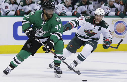 Dallas Stars defenseman Johnny Oduya skates with the puck against Minnesota Wild right wing Jason Pominville during the second period of Game 1 in a first-round NHL hockey Stanley Cup playoff series Thursday