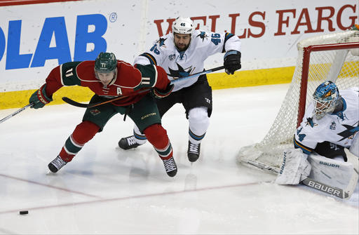 Minnesota Wild's Zach Parise left is impeded in his race to the puck by San Jose Sharks Roman Polak of Czech Republic as goalie James Reimer right defends in the third period of an NHL hockey game Tuesday