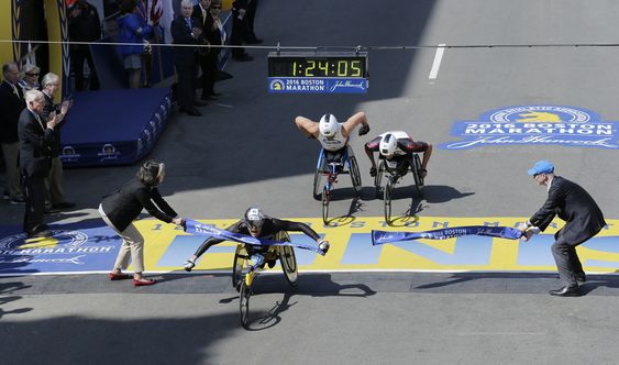 Switzerland breaks the tape ahead of Kurt Fearnley of Australia center and Ernst Van Dyk of South Africa in the wheelchair division of the 120th Boston Marathon on Monday