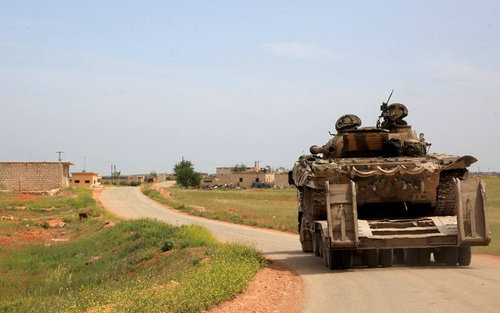 Syrian tanks patrol the town of Khan Tuman