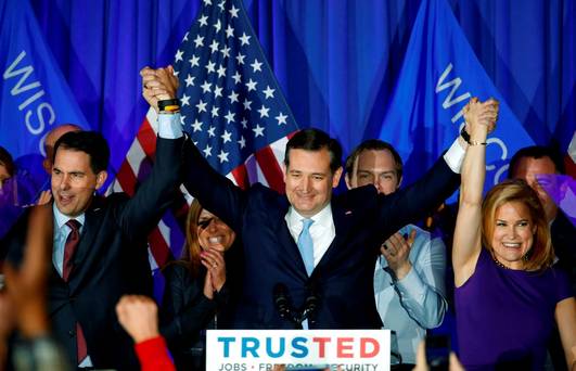 Republican presidential candidate Senator Ted Cruz raises hands with Wisconsin Governor Scott Walker left and his wife Heidi right during a primary night campaign event