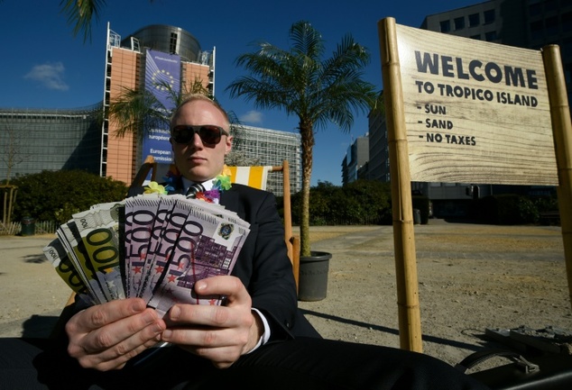 An activist performs as a client of an offshore company during a protest by'Oxfam and'Transparency International in front of the European Commission head