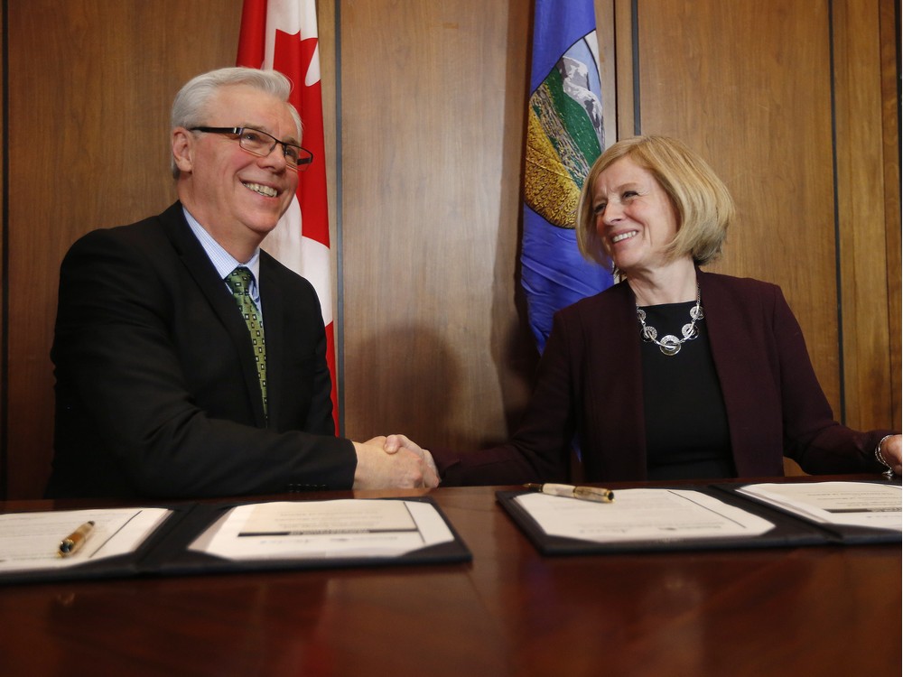 Manitoba Premier Greg Selinger and Alberta Premier Rachel Notley sign a memorandum of understanding on shared energy and climate change Friday