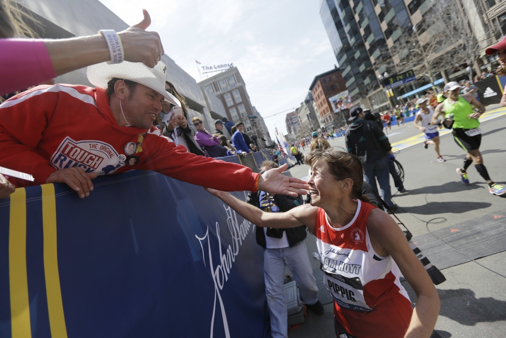 Carlos Arredondo left a 2013 Boston Marathon bombing first-responder greets three-time Boston Marathon women's division winner Uta Pipping after she crossed the finish line of the 120th Boston Marathon on Monday