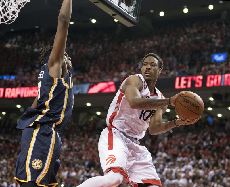 Toronto Raptors&#039 guard De Mar DeRozan looks to pass around Indiana Pacers&#039 forward Myles Turner