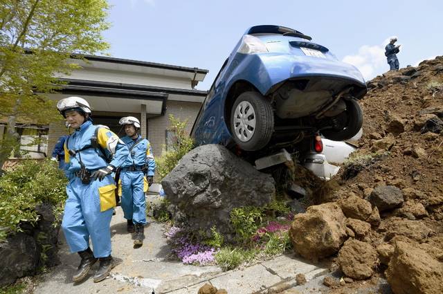 Police officers conduct a search operation at the site of a landslide caused by an earthquake in Minamiaso Kumamoto prefecture Japan Sunday