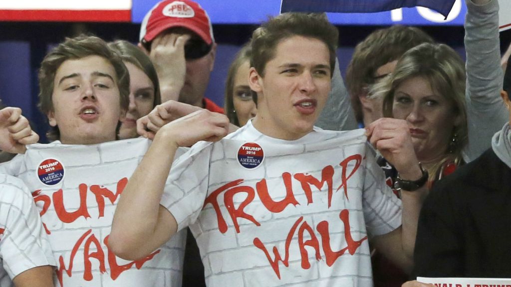 Supporters of Republican presidential candidate Donald Trump chant'Build That Wall before a town hall Saturday