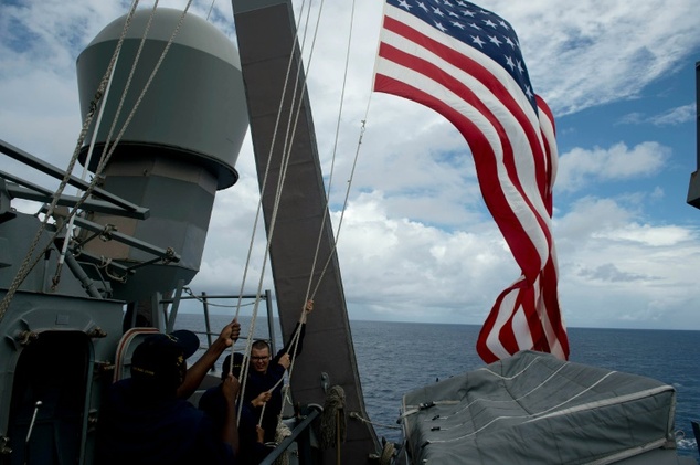 US Navy personnel raise their flag during a bilateral maritime exercise with the Philippine Navy in the South China Sea in 2014