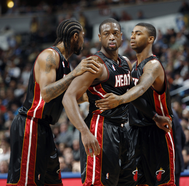 Miami Heat guard Dwyane Wade center is held back by teammates Udonis Haslem left and Dorell Wright after Wade was