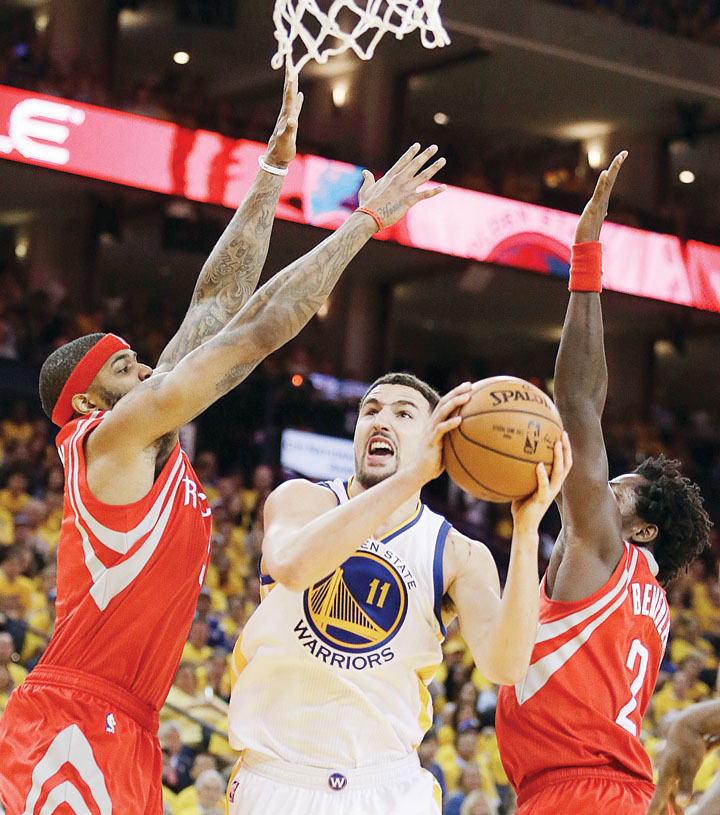 Klay Thompson of the Golden State Warriors attempts to score off Josh Smith and Patrick Beverley of the Houston Rockets during their NBA playoff game in Oakland. Golden State won 115-106