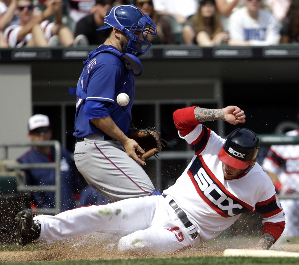 Brett Lawrie scores on a sacrifice fly by Dioner Navarro as Texas Rangers catcher Brett Nicholas misses the ball during the fifth inning Sunday