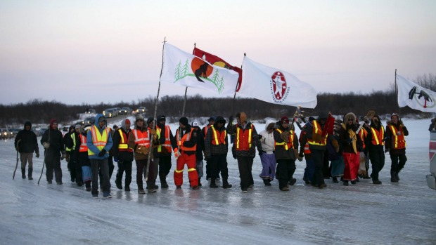 Youths from three First Nations communities cross the frozen Attawapiskat river during a march