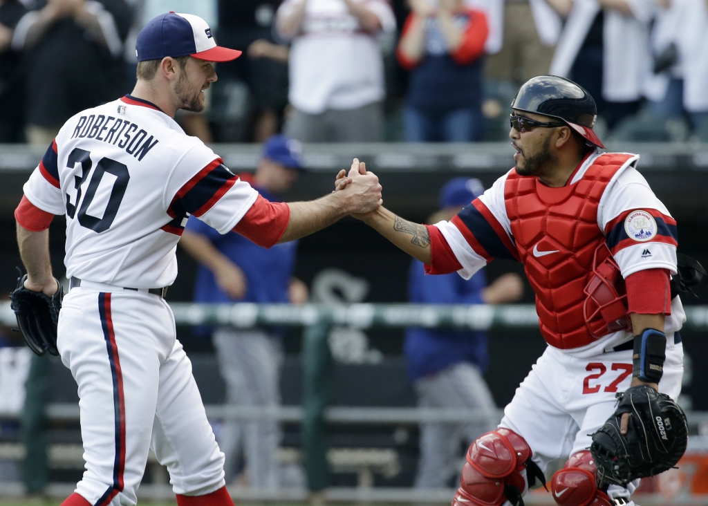 Chicago White Sox closer David Robertson left celebrates with catcher Dioner Navarro after defeating the Texas Rangers 4-1 in a baseball game Sunday