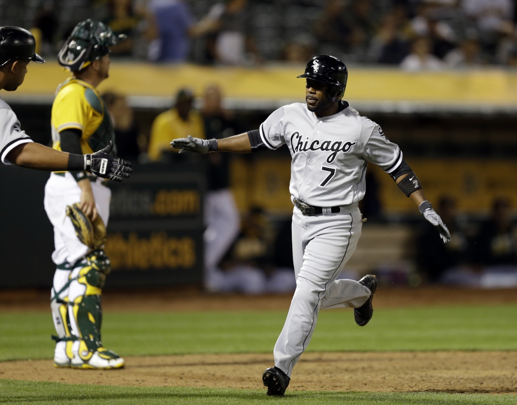 Jimmy Rollins crosses home plate to score after hitting a home run off Oakland Athletics&#039 Sean Doolittle during the ninth inning of a baseball game Tuesday