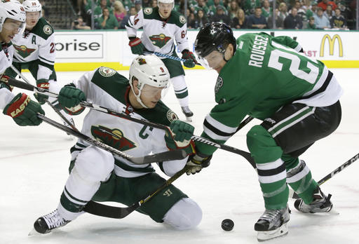 Minnesota Wild center Mikko Koivu and Dallas Stars left wing Antoine Roussel battle for the puck during the first period in Game 2 in the first round of the NHL Stanley Cup playoffs Saturday