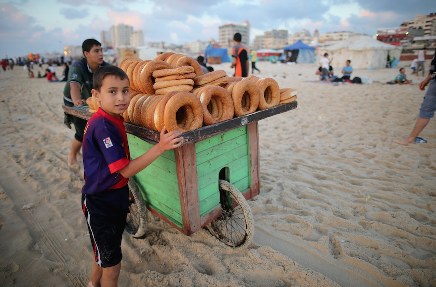 Young children selling bread snacks on Gaza beach in Gaza City Gaza