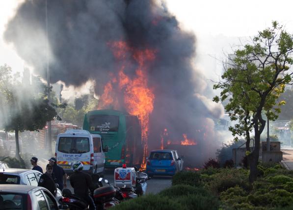 Flames rise at the scene where an explosion tore through a bus in Jerusalem on Monday setting a second bus on fire in what an Israeli official said was a bombing